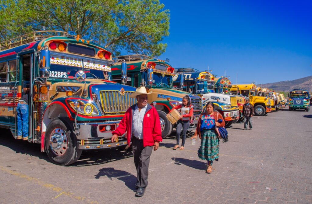 Csirkebusz Guatemalában, előtte emberek sétálnak.